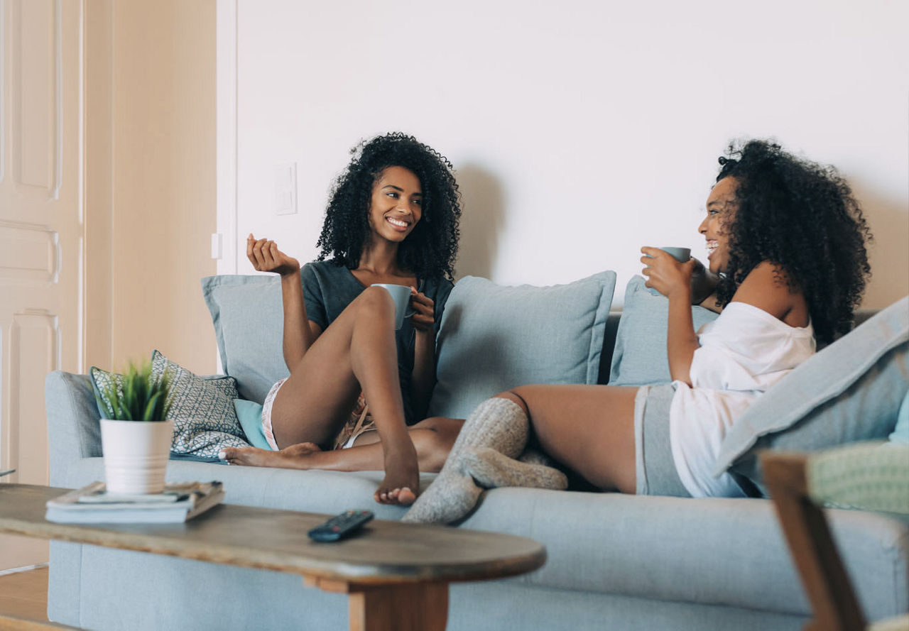 Two friends relaxing on couch | Blog | Greystar